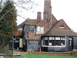 Peg tiles cover the roof slopes of this Arts & Crafts house in North London and hanging tiles cover its gables.
