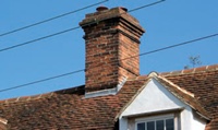 Mortar fillets are commonly used at the junction between peg tiles and a chimney (shown above), but lead flashings (shown here) are much more reliable.